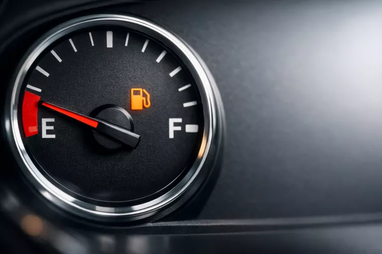 Tankanzeige auf Reserve: Zeiger nahe „E“ als Symbol für leere Energie und Self-Care als Basis.